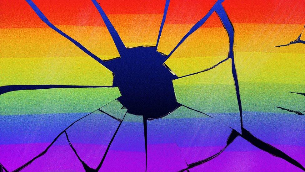 Broken window with LGBT flag