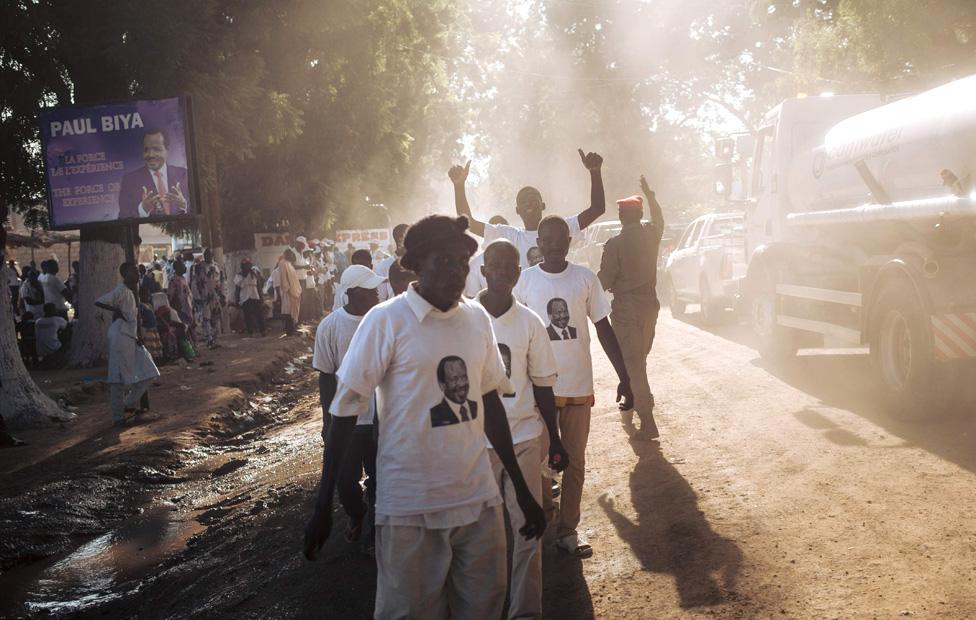 In this photograph taken on September 29, 2018, supporters of the President Paul Biya walk in a street of Maroua, Far North region of Cameroon, after sn electoral meeting he held in the city.