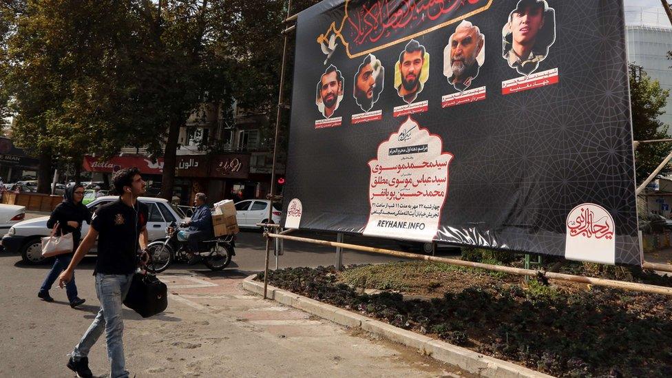 A man walks past a poster showing prominent Iranian Revolutionary Guards commanders who have been killed in Syria (27 October 2015)