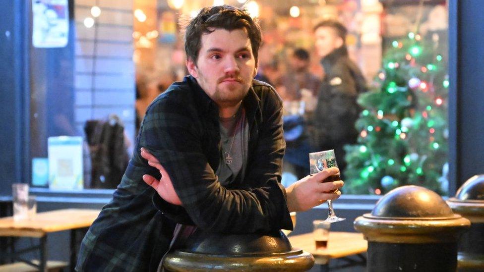 A man looks on with a pint of beer in Cardiff