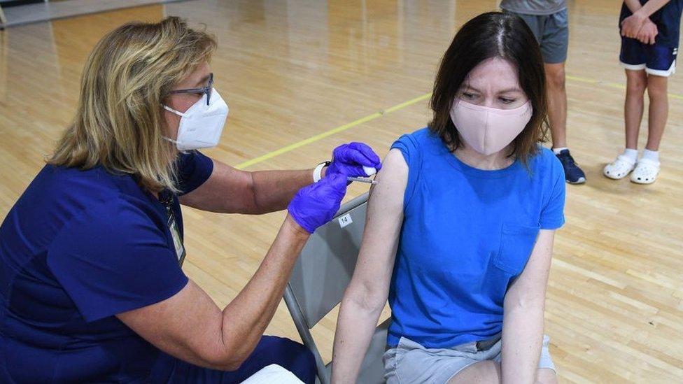 A nurse gives a girl a jab