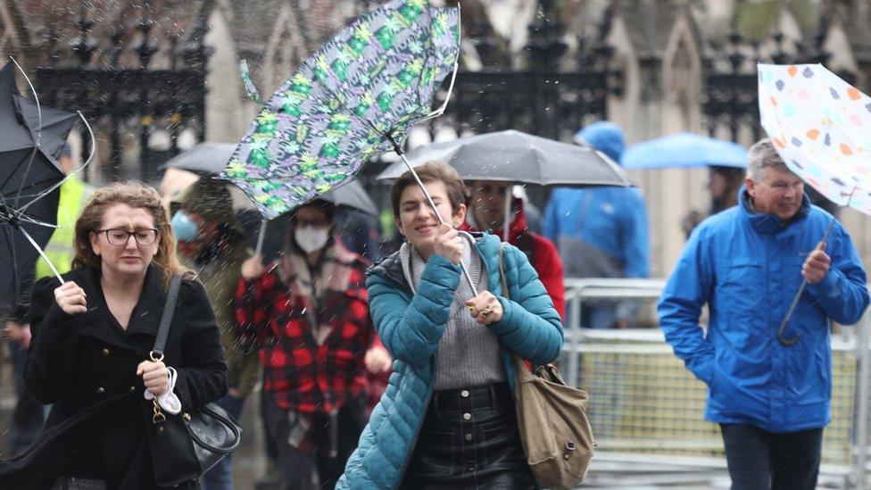 Members of the public brace the wind and wet weather in Westminster in central London on Saturday.