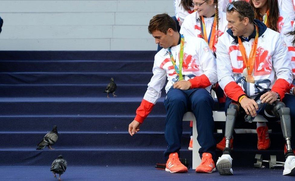 Tom Daley reacts to pigeons on stage alongside Richard Whitehead