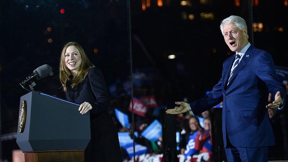 Chelsea Clinton delivering a speech, supported by her father Bill Clinton