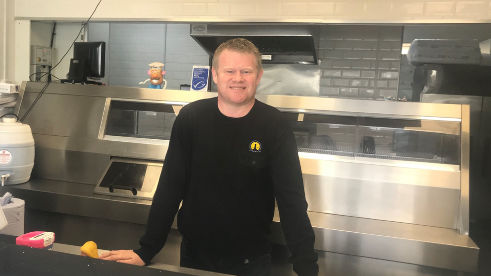 President of the National Federation of Fish Friers, behind the counter of a fish and chip shop