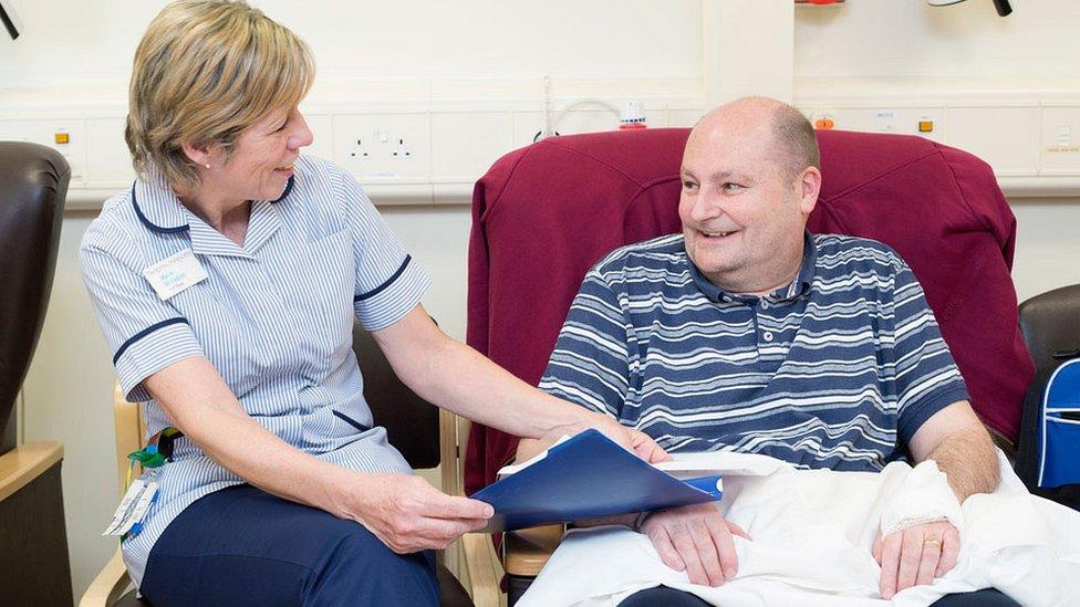 philip malling receiving treatment with nurse holding his hand