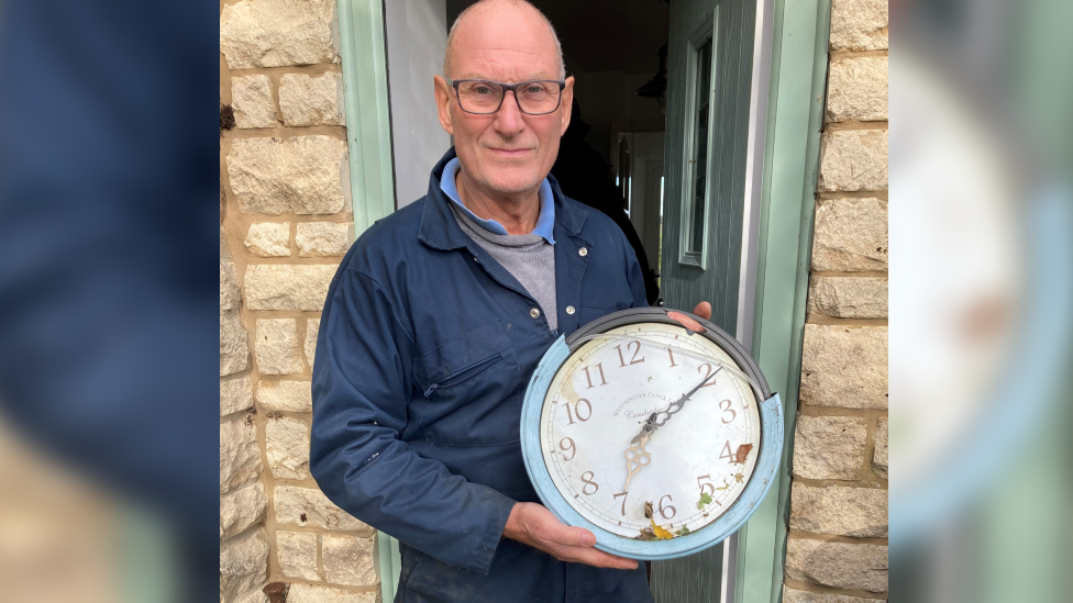 Roy Mercer holding a broken clock