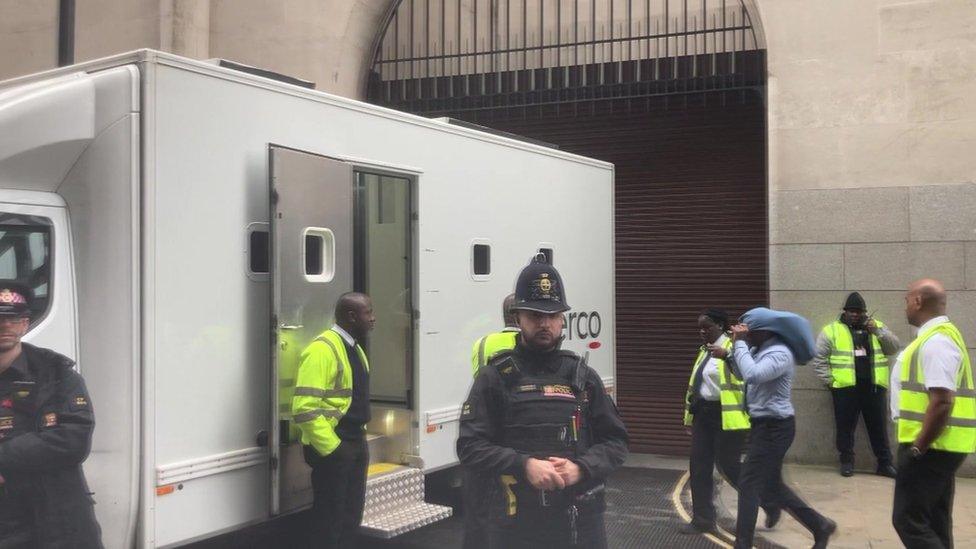 A defendant being led to a prison van