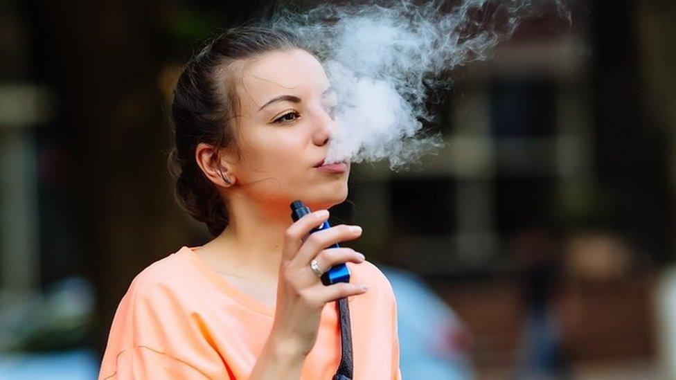 A young woman seen smoking a vape