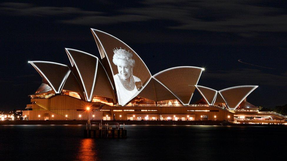 Image shows Sydney Opera House with image of Queen