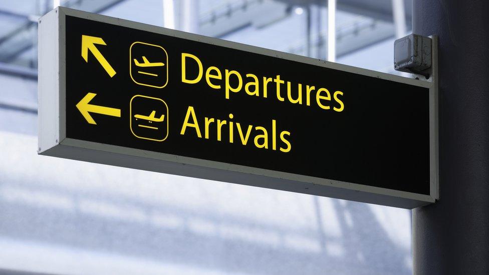 Sign pointing the way to Departures and Arrivals at an airport.