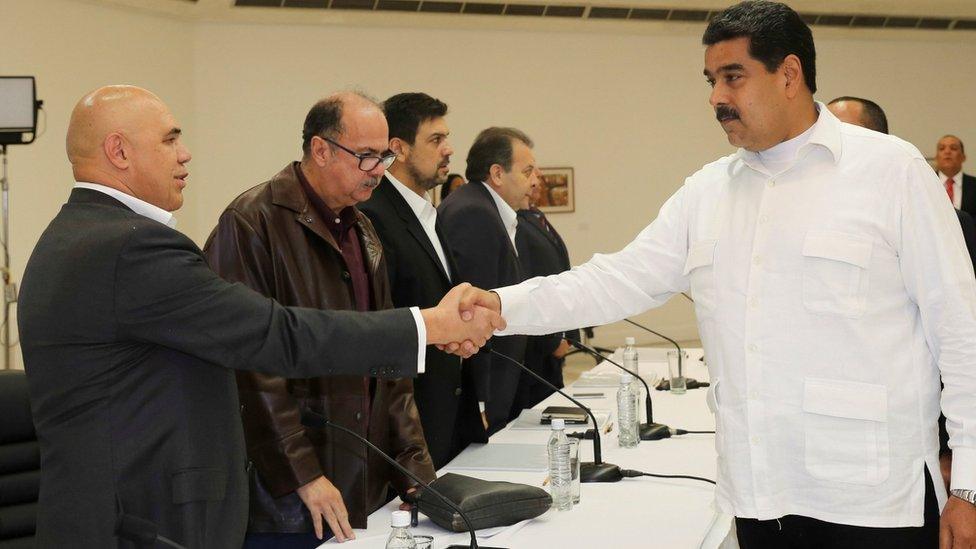 President Nicolas Maduro (R) shakes hands with opposition leader Jesus Torrealba during political meeting between government and opposition, in Caracas, Venezuela October 30, 2016