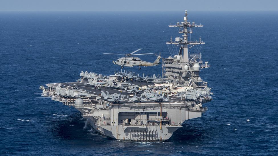 A handout photo made available by the United States Department of Defense (DoD) shows an MH-60R Sea Hawk from the Helicopter Maritime Strike Squadron (HSM) 78 "Blue Hawks" flying near the aircraft carrier USS Carl Vinson (CVN 70) at sea in the Philippine Sea, 24 April 2017