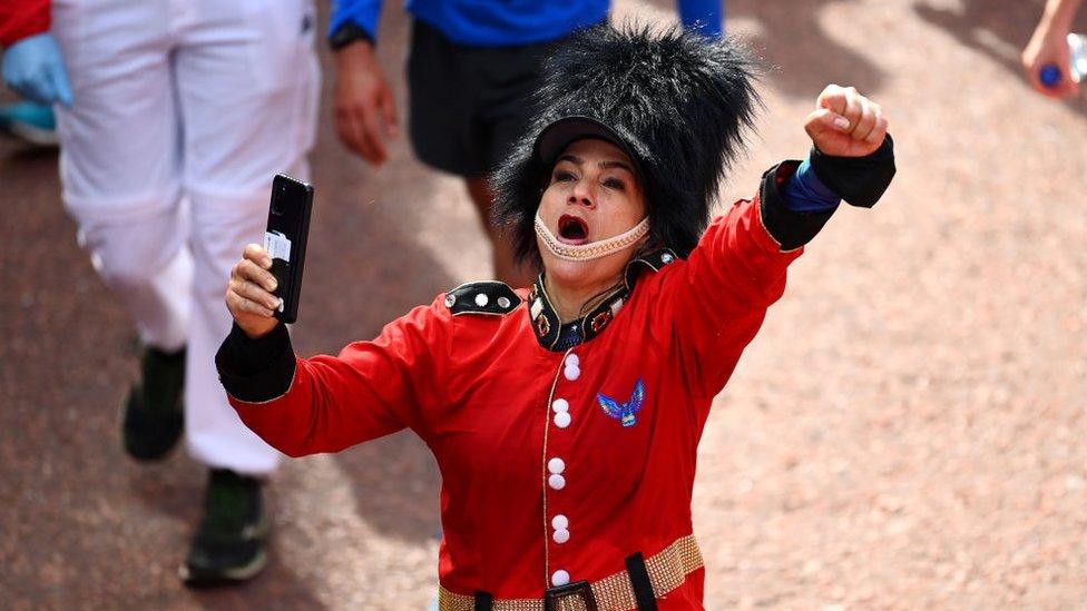 woman-celebrates-punching-air-while-wearing-london-guard-uniform