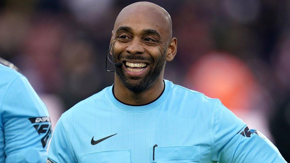 Sam Allison dressed in a blue football kit smiling