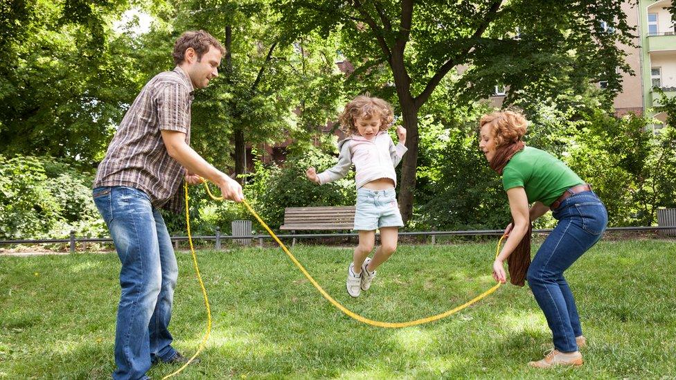 girl-skipping-over-rope-with-parents