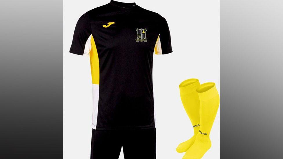 Image shows the Abbey Rangers FC kit which is a black top and shorts and yellow socks