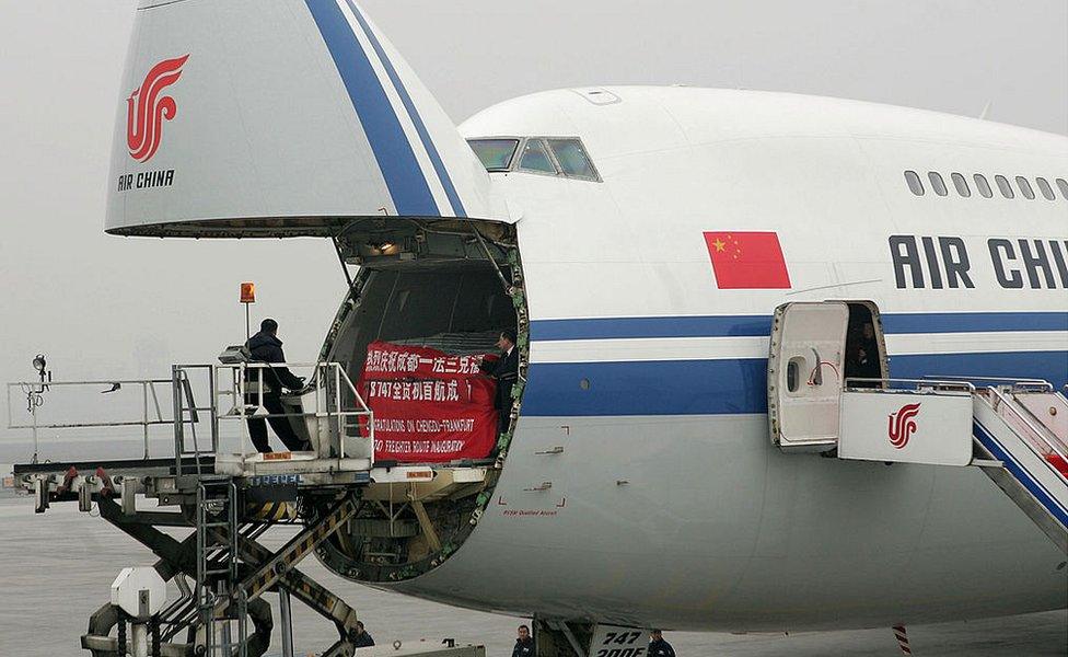 Workers load a Boeing 747-200 freighter of Air China at Chengdu Shuangliu International Airport