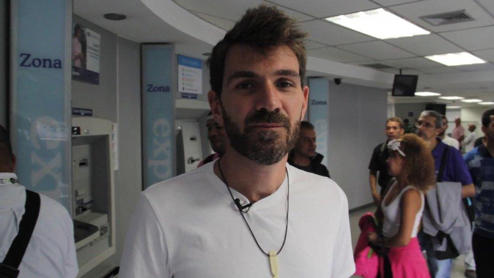 Guillermo Olmo pictured reporting from a bank in Caracas