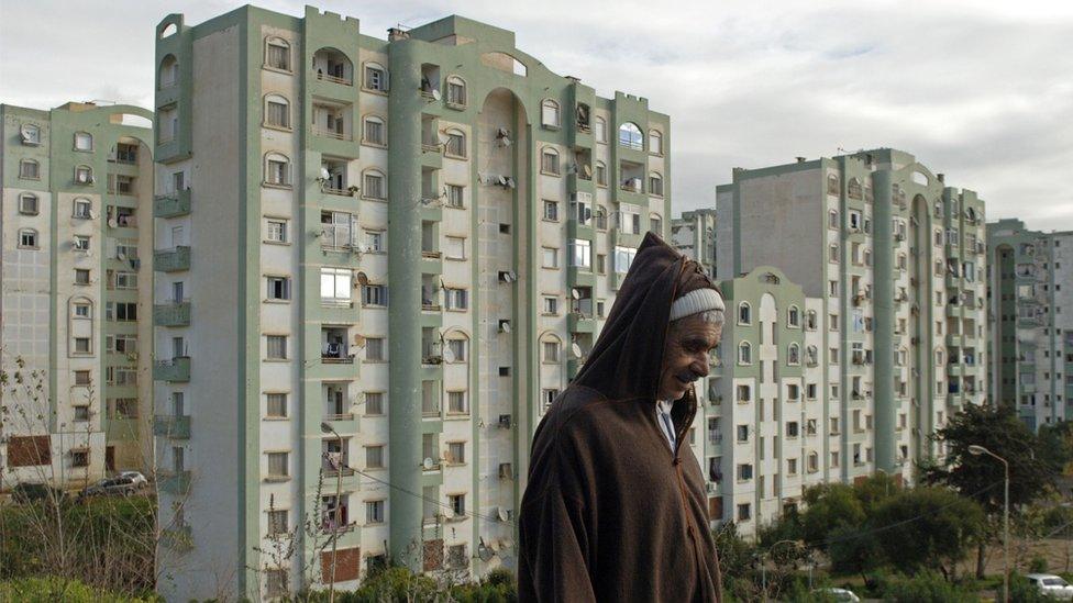 An Algerian man walks in one of the many new residential districts outside the capital Algier