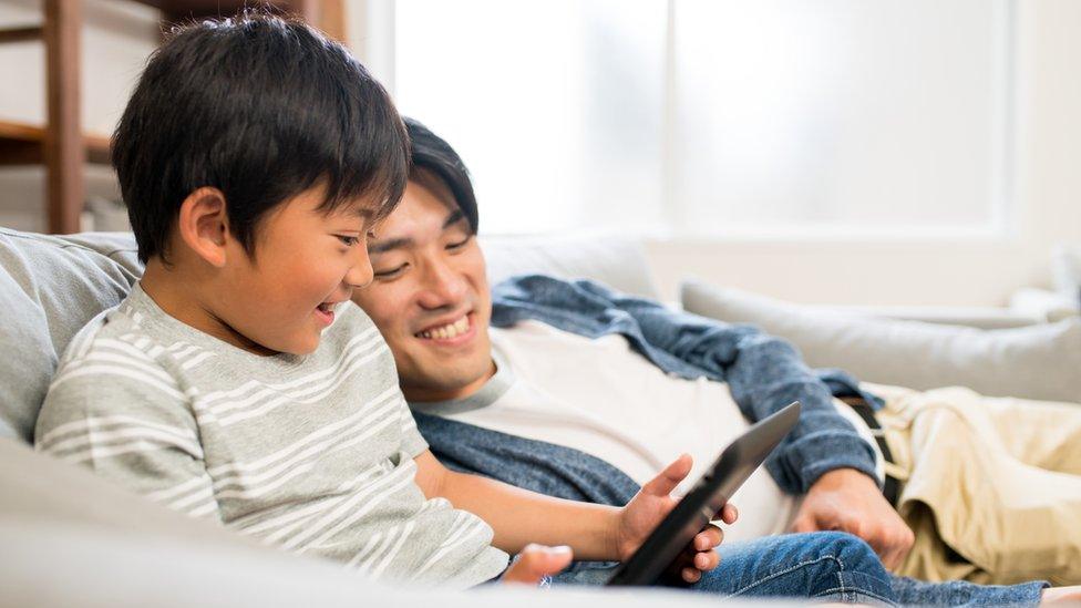 Dad and son using ipad together