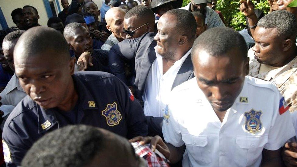 Haitian Senator Willot Joseph scuffles with opposition supporters as he arrives at Congress