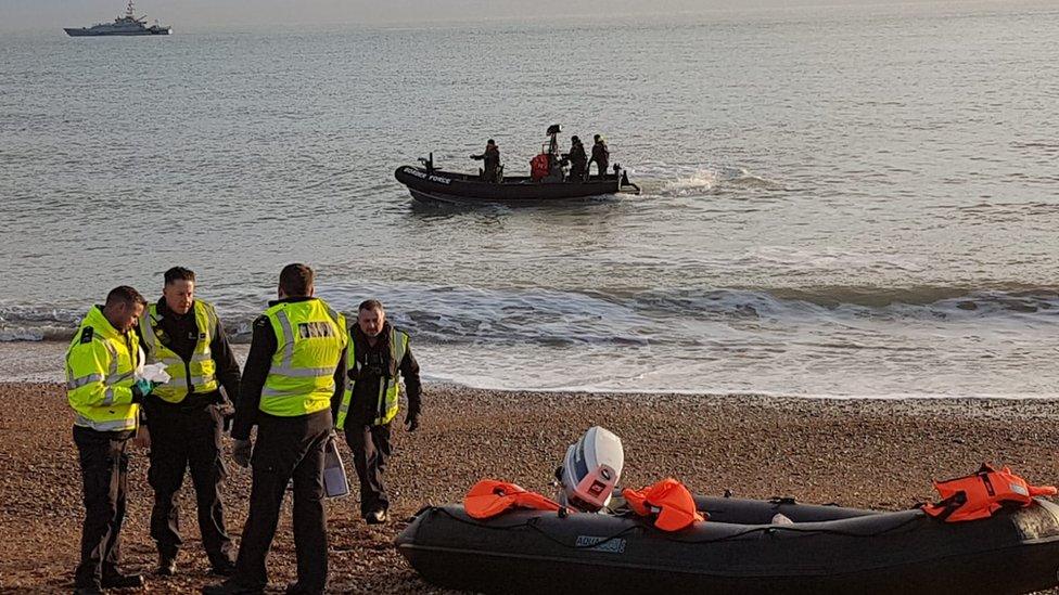 Border force officials by a dinghy