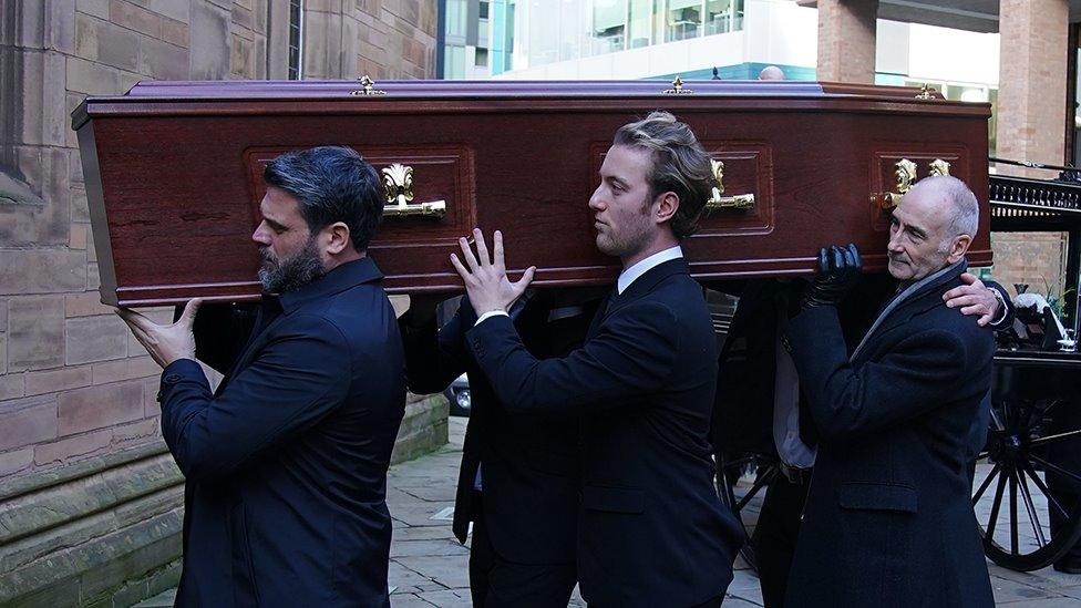 coffin being carried into the church