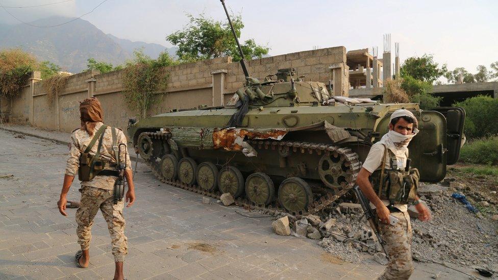 Pro-government fighter army troops walk in a position they retook from Houthi fighters near the Republican Palace in the north-western city of Taiz