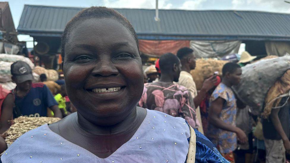 A woman in a market smiling at the camera