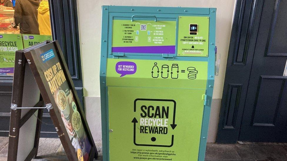 A bin for a trial deposit return scheme in Brecon, which has "Scan, Recycle, Reward" written on a green bin.