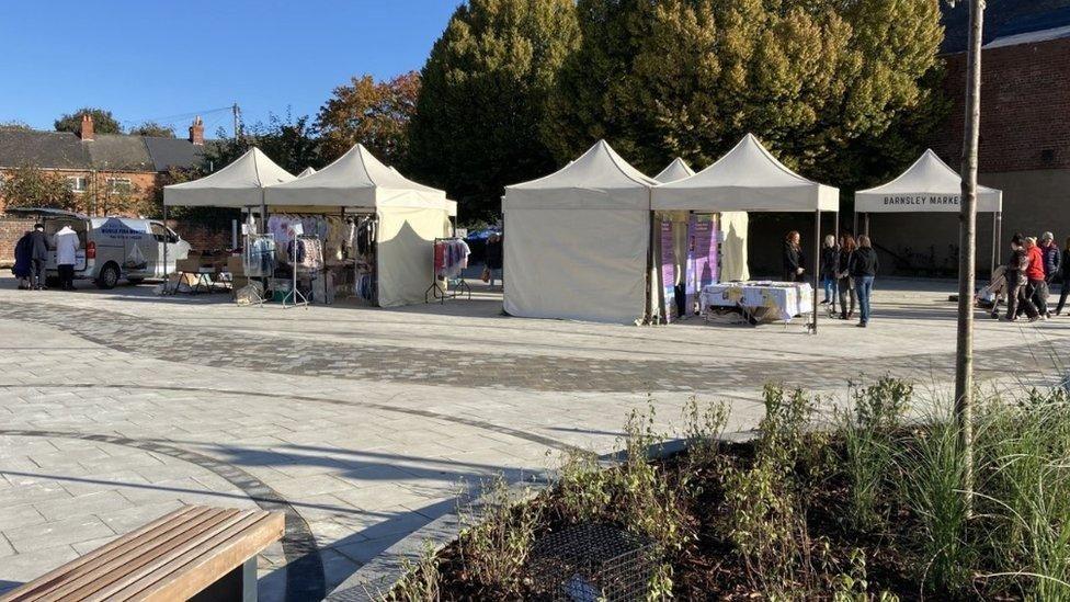 A market square with several beige gazebos