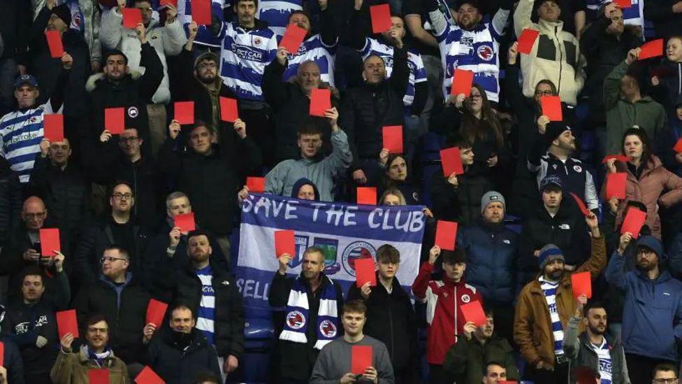 Protesting Reading fans in a stand holding large red cards