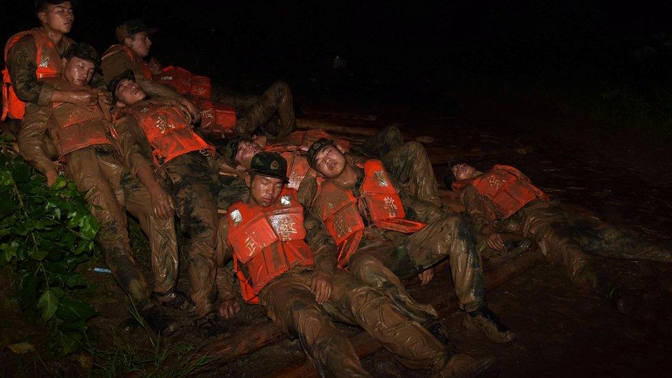 Paramilitary policemen rest as they take turns to try to fill up a break in a dam in preparation for Typhoon Nepartak which is approaching China, in Lujiang county, Anhui province, China, July 8, 2016