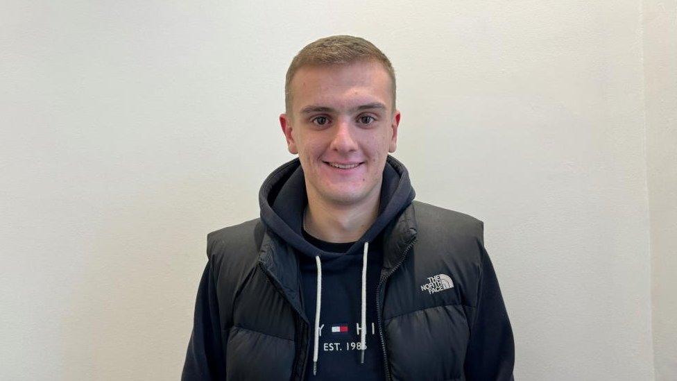 Man with short light-coloured hair wearing tracksuit top