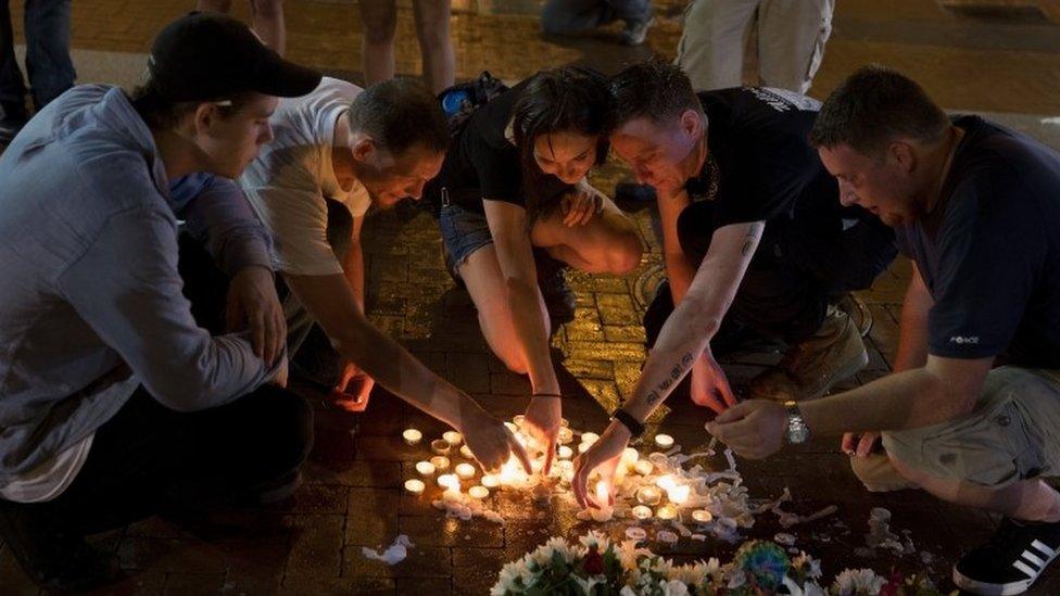 People place candles in a vigil after violent protests in Charlottesville, Virginia