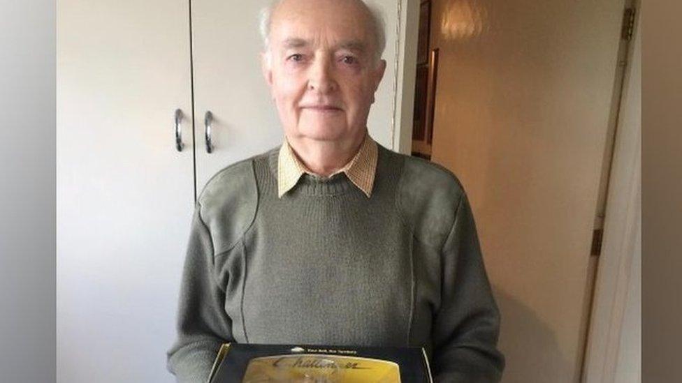 Jim Russell holding tractor memorabilia