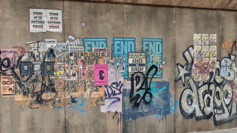 Fake graffiti and posters on the nearby walls of the court building create part of the film set