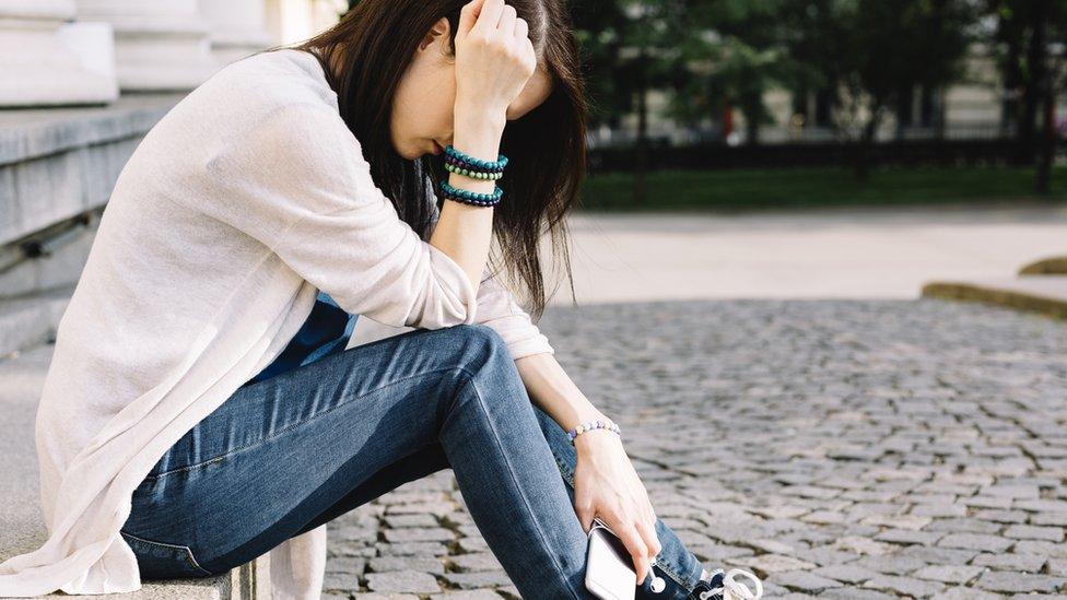 Young girl sitting in the street