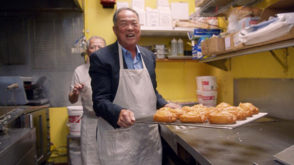 Ted carrying a tray of douhgnuts