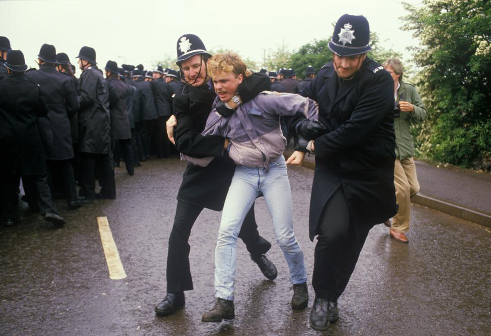 Two policemen restrain a miner, Orgreave 1984