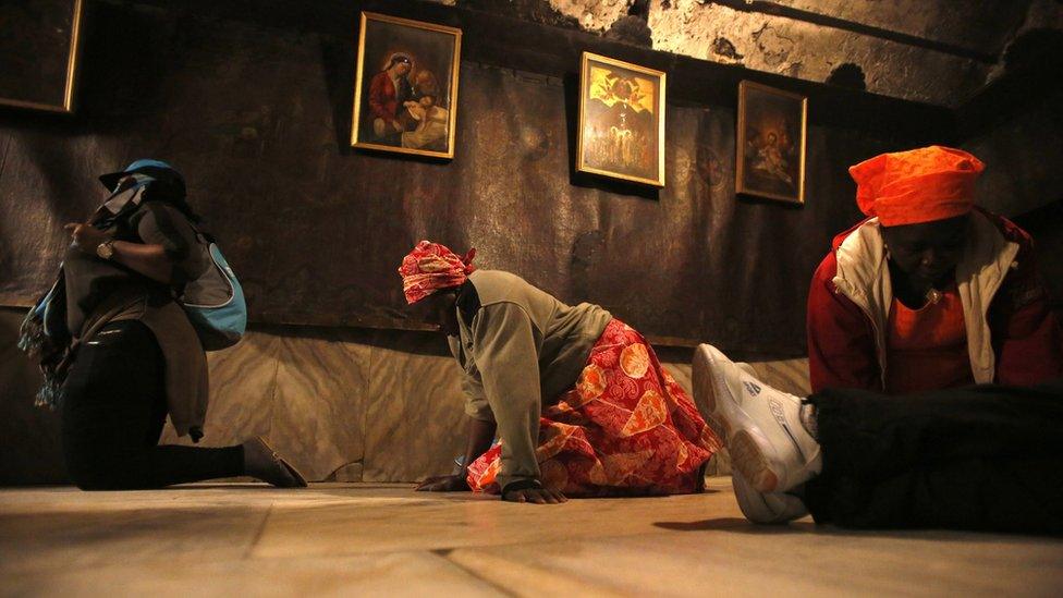 Christian pilgrims from Nigeria pray in the "Grotto" in the Church of the Nativity, accepted by Christians as the birthplace of Jesus Christ, in the West Bank town of Bethlehem