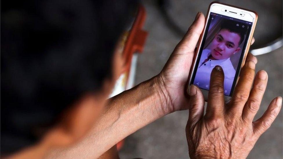 The father of Hoang Van Tiep shows his picture on a mobile phone