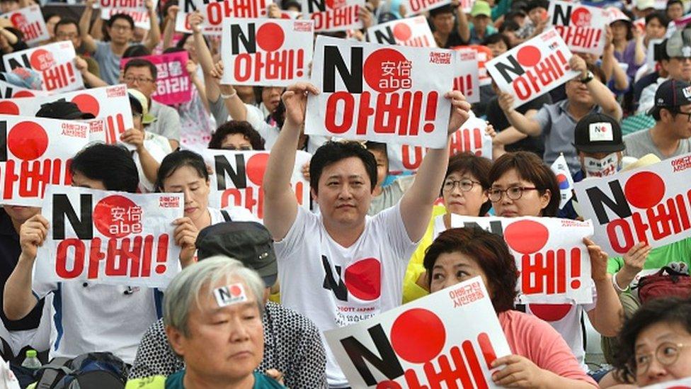 South Korean protesters hold signs reading "No Abe!" during an anti-Japanese rally