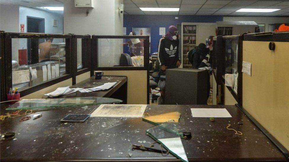 Anti-government demonstrators loot and later destroy the property of a branch of the Banco Provincial bank which works inside the administration headquarters of the Supreme Court of Justice after attacking and invading the building as part of protests against President Nicolas Maduro in Caracas, on June 12, 2017.