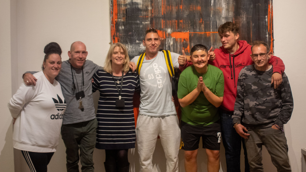 Artists standing in front of a painting