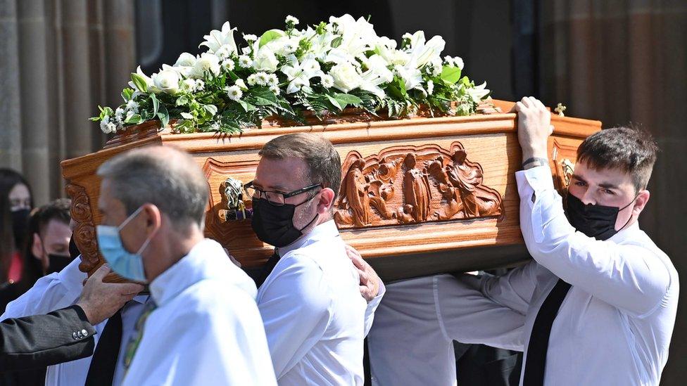 A group of pallbearers carrying the coffin of Samantha Willis