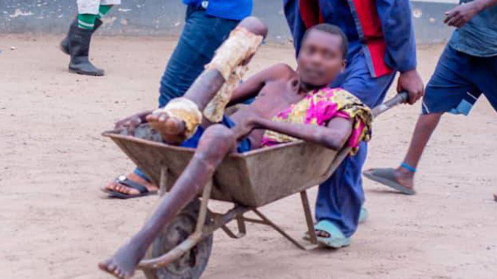 A man being pushed in a wheelbarrow