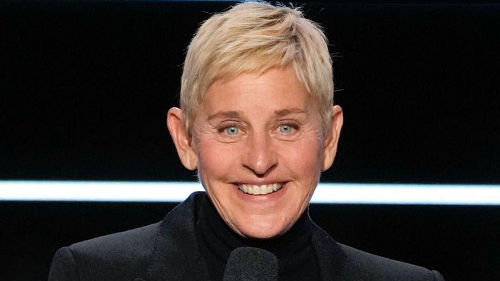Ellen DeGeneres wearing a black jacket, smiling and speaking at the Carol Burnett: 90 Years of Laughter + Love - Season 2023