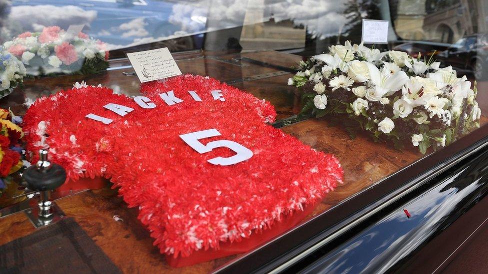 Floral tribute in the shape of a red England shirt bearing the number 5